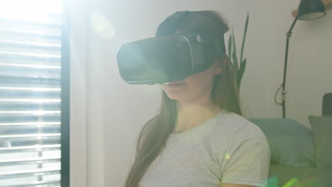 Girl-having-fun-using-a-VR-headset,-watching-and-catching-virtual-objects